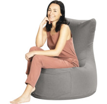 Een vrouw zit in een grijze zitzak met een hoge rugleuning van textiel.