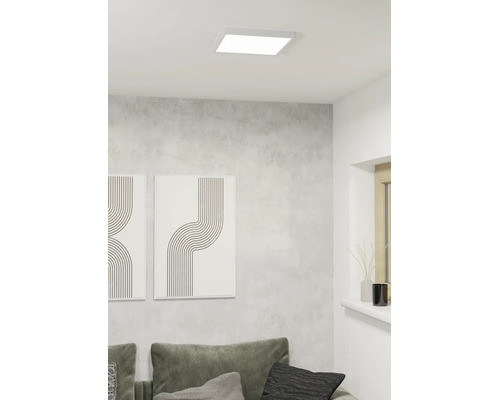 Vierkant LED-plafondpaneel in een moderne woonkamer met grijze wand en minimalistische decoratie.