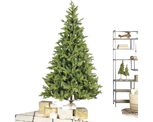 Kunstkerstboom in een lichte kamer met ingepakte cadeaus, een moderne metalen stellingkast en een vloerkleed met ruitpatroon.