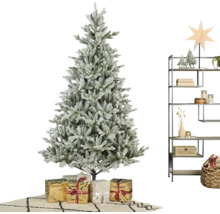 Kunstkerstboom met sneeuweffect, cadeaus en een metalen stellingkast met winterse decoratie in een lichte kamer.