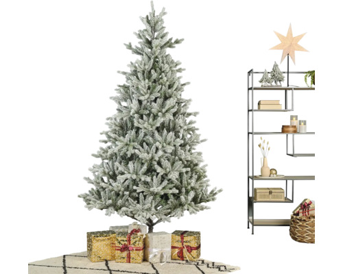 Kunstkerstboom met sneeuweffect, cadeaus en een metalen stellingkast met winterse decoratie in een lichte kamer.
