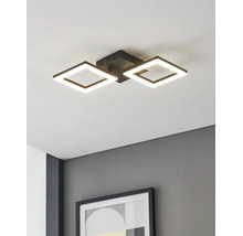 Moderne LED-plafondlamp met twee vierkante zwarte frames, gemonteerd aan een wit plafond boven een grijze muur met een ingelijste foto.