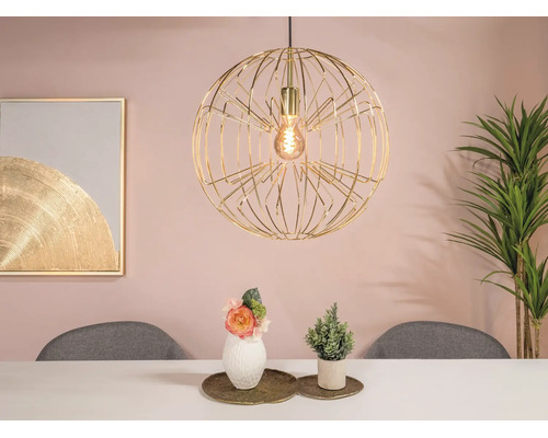 Moderne bolvormige hanglamp van goudkleurig draadwerk boven een eettafel in een lichte, modern ingerichte eetkamer.
