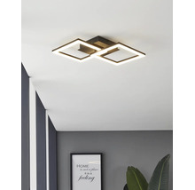 Moderne zwarte LED-plafondlamp met twee in elkaar grijpende vierkante lichtframes in een modern ingerichte kamer.