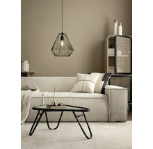 Moderne woonkamer met corduroy bank, zwarte draadhanglamp, driehoekige salontafel en een kast met rotan deuren.