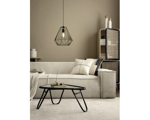 Moderne woonkamer met corduroy bank, zwarte draadhanglamp, driehoekige salontafel en een kast met rotan deuren.