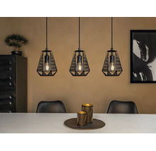 Drievlammige hanglamp met zwarte metalen draadkappen en zichtbare lichtbronnen boven een eettafel in een modern interieur.