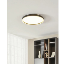 Moderne, ronde LED-plafondlamp in een minimalistisch interieur boven een donkergrijze plank.