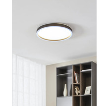 Moderne ronde LED-plafondlamp in een licht, georganiseerd interieur met een kast en gordijn.