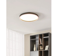 Moderne, ronde LED-plafondlamp met warmwit licht en een gekleurde rand aan een plafond in een lichte, georganiseerde kamer met een kast.