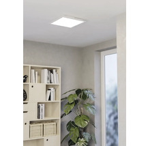 Vierkant LED-paneel aan het plafond in een modern ingerichte lichte kamer met boekenkast en grote kamerplant.