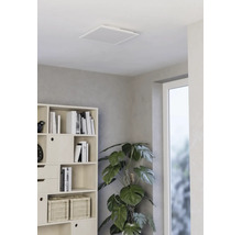 Vierkant LED-plafondpaneel in een lichte, moderne woonkamer met een stellingkast en een kamerplant.