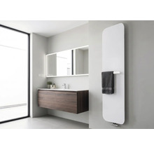 Moderne verticale designradiator in een lichte badkamer met donker wastafelmeubel en verlichte spiegel.