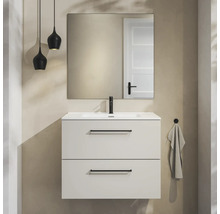 Moderne badkamermeubelset met witte wastafelonderkast, twee laden met zwarte handgrepen, zwarte kraan, spiegel en twee hanglampen.