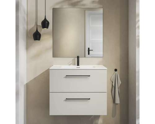 Moderne badkamermeubelset met witte wastafelonderkast, twee laden met zwarte handgrepen, zwarte kraan, spiegel en twee hanglampen.
