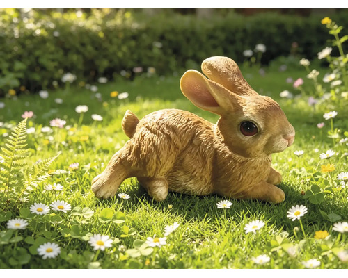 Tuinfiguur konijn zittend in een grasveld met bloemen, gedetailleerde replica met natuurgetrouwe vachtstructuur.