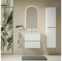 Moderne badkamer met wit wastafelmeubel, hoge zijkast, boogvormige spiegel met verlichting en douche met botanisch bladmotief.