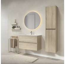 Moderne badkamerset met wastafelmeubel in lichte houtlook, wastafel, ronde verlichte spiegel en bijpassende hoge kast.