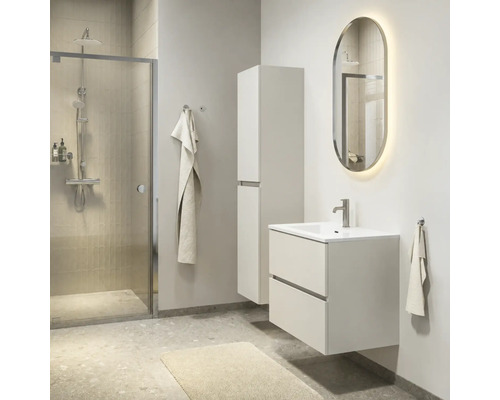 Moderne badkamer met wit wastafelmeubel, hoge zijkast, verlichte ovale spiegel en een inloopdouche.