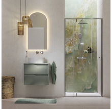 Moderne badkamer met groen wastafelmeubel, opzetwaskom, boogvormige spiegel met verlichting en glazen douche met groen gemarmerde achterwand.