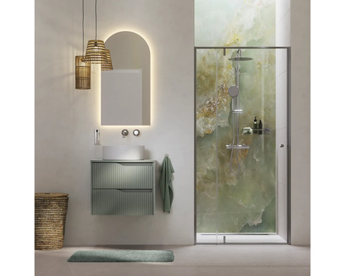 Moderne badkamer met groen wastafelmeubel, opzetwaskom, boogvormige spiegel met verlichting en glazen douche met groen gemarmerde achterwand.