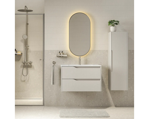 Moderne badkamer met hangend wastafelmeubel met ribbelstructuur, verlichte ovale spiegel, hoge kast en inloopdouche.