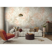 Moderne woonkamer met vliesbehang met palmbladmotief, een witte bank, een oranje fauteuil en een ronde salontafel.