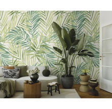 Fotobehang met grote palmbladeren in een lichte woonkamer met moderne meubels en kamerplant.