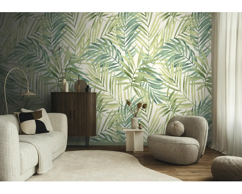 Vliesbehang met palmbladmotief in een modern ingerichte woonkamer met een lichte bank en een donkere houten kast.