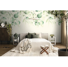 Lichte slaapkamer met een grote fotobehang van groene botanische bladeren, een bed met licht beddengoed en een donkerhouten kast.
