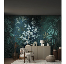 Woonkamer met donker botanisch fotobehang, lichte fauteuil, dressoir en decoratieve accessoires op een licht tapijt.