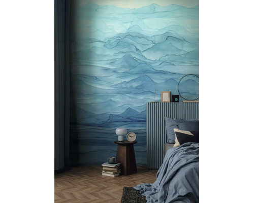 Slaapkamer met fotobehang in aquarelstijl, berglandschap in blauw, bed met geribbelde hoofdsteun en visgraatparket.