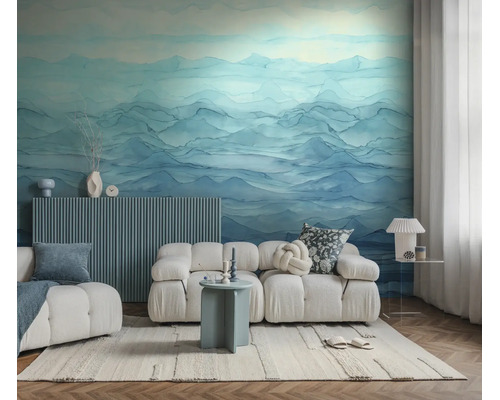 Moderne woonkamer met fotobehang van een abstract berglandschap. De lichte kamer heeft een modulaire bank en een vloerkleed met textuur.