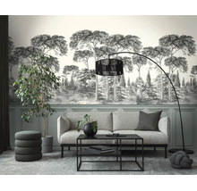 Moderne woonkamer met fotobehang van een boslandschap in grijstinten, grijze bank, zwarte salontafel, booglamp en kamerplanten.