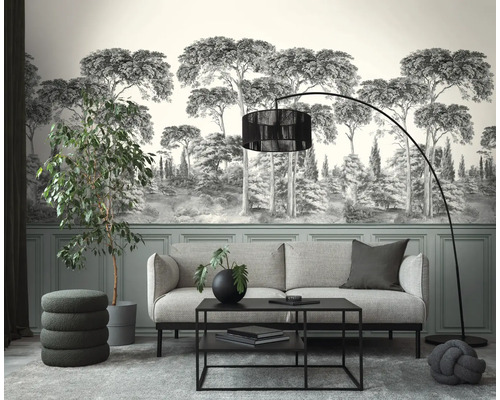 Moderne woonkamer met fotobehang van een boslandschap in grijstinten, grijze bank, zwarte salontafel, booglamp en kamerplanten.