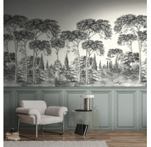 Lichte woonkamer met monochroom fotobehang met boslandschap boven groene lambrisering, een witte fauteuil en een transparante bijzettafel.
