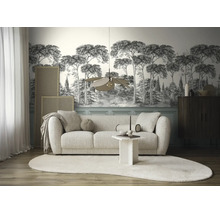 Woonkamer met een moderne bank, een designlamp en fotobehang met een boslandschap in zwart-wit.