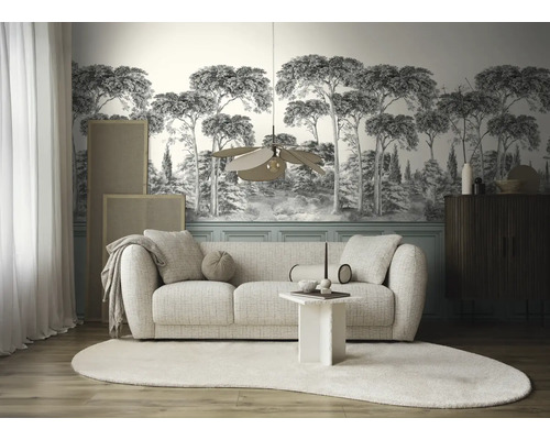 Woonkamer met een moderne bank, een designlamp en fotobehang met een boslandschap in zwart-wit.