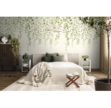 Fotobehang met hangende bladeren in een lichte slaapkamer met tweepersoonsbed, nachtkastjes en kamerplanten.
