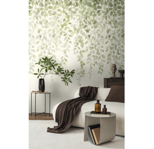 Vliesbehang met hangend bladmotief in aquarelstijl in een modern ingerichte woonkamer met bank en bijzet tafel.