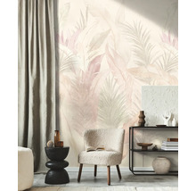 Vliesbehang met tropisch bladmotief in pasteltinten in een modern ingerichte woonkamer met fauteuil en open kast.
