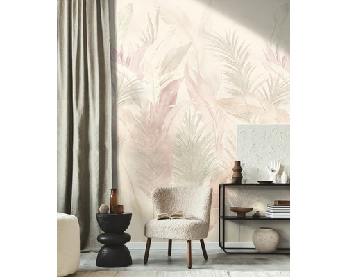 Vliesbehang met tropisch bladmotief in pasteltinten in een modern ingerichte woonkamer met fauteuil en open kast.
