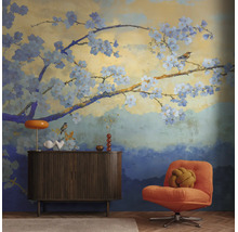 Fotobehang met kersenbloesemtakken en vogels in Japanse stijl in een modern ingerichte, lichte woonkamer met dressoir en fauteuil.
