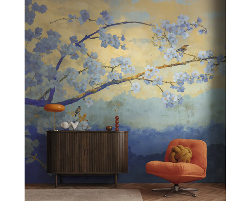 Fotobehang met kersenbloesemtakken en vogels in Japanse stijl in een modern ingerichte, lichte woonkamer met dressoir en fauteuil.