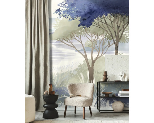 Fotobehang met schilderachtig landschap in blauw en groen, moderne woonkamer met bouclé fauteuil en zwart rek.
