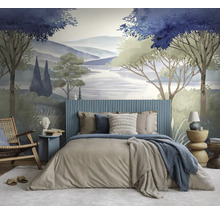Slaapkamer met fotobehang van een geschilderd landschap met bomen, heuvels en meer. Bed met blauw hoofdbord, houten stoel en bijzettafel.