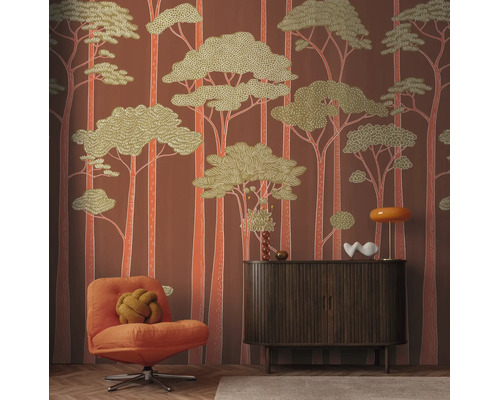 Vliesbehang met gestileerd bosmotief in retrostijl, gecombineerd met een houten dressoir, een fauteuil en woonaccessoires.
