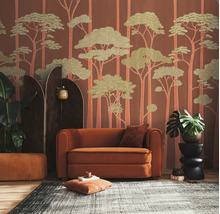 Vliesbehang met bosmotief in een woonkamer met oranje fauteuil, donker kamerscherm, kamerplanten en een tapijt met patroon.