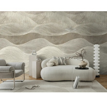 Moderne woonkamer met behang met een golvend patroon in neutrale tinten, een witte bank en een grijze fauteuil voor een lichte sfeer.