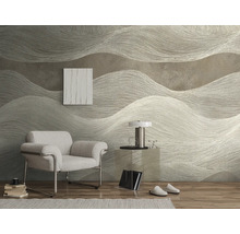 Gestructureerd behang met groot golfpatroon in een modern ingerichte kamer met lichte fauteuil, glazen tafel en houten vloer.